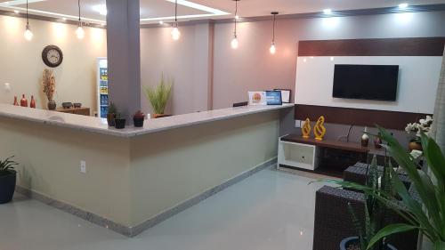 an office with a reception counter with a tv on the wall at Pousada Maragolfinho in Maragogi