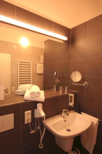 a bathroom with a sink and a mirror at Hotel Sunnegässle in Rust