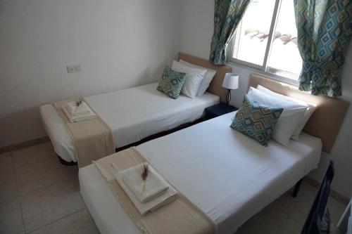 a room with two beds and a couch and a window at Los Trigos, Casa Rural in Montejaque