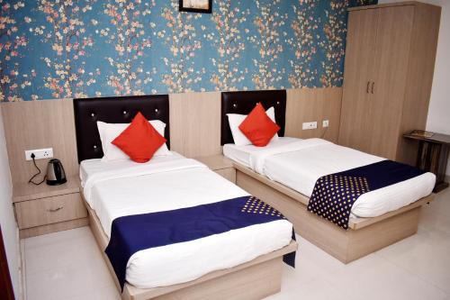 Una habitación con dos camas con papel pintado rojo y azul. en HOTEL UMA PALACE, en Gorakhpur