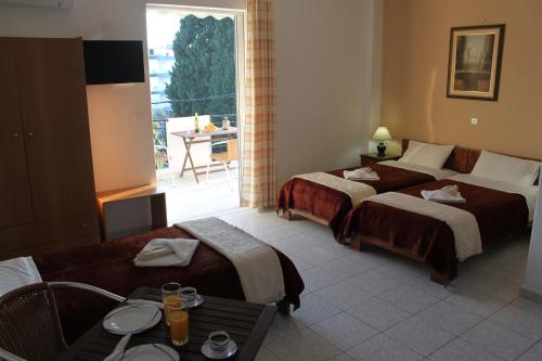 a hotel room with two beds and a balcony at 123 Armonia Studios in Loutra Edipsou