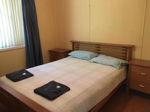 a bedroom with a bed with two hats on it at Cottage 53 - Topspot Cottages in Jurien Bay