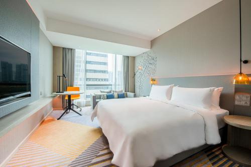 a hotel room with a large bed and a television at Holiday Inn Johor Bahru City Centre by IHG in Johor Bahru