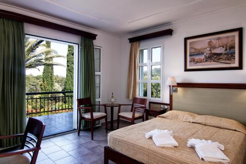 a hotel room with a bed and a balcony at Arion Hotel in Kokkari
