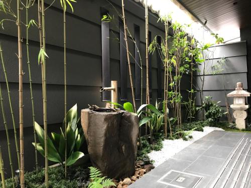a garden with a fountain and some bamboo at Hauza Kyoto Gojo Karasuma in Kyoto