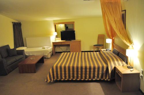 a hotel room with a bed and a couch at Four Seasons Hotel in Trílofon