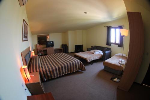 a hotel room with two beds and a couch at Four Seasons Hotel in Trílofon