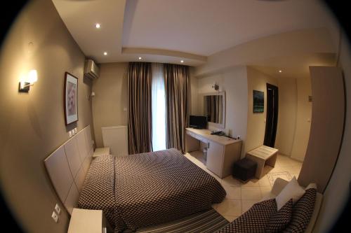 a small room with a bed and a desk in it at Four Seasons Hotel in Trílofon
