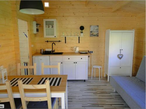een keuken en eetkamer met een tafel in een huisje bij STAŁY LĄD in Ustronie Morskie