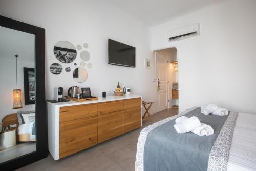 
a bedroom with a bed and a dresser at Harmony Boutique Hotel in Mýkonos City
