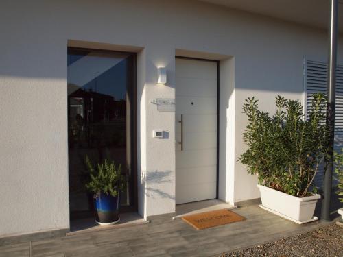 a house with two potted plants next to a door at B&B Ramerino in Grosseto