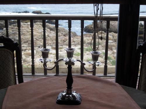 a dining room table with a view of the ocean at Hotel Boutique Castillo del Mar in El Quisco