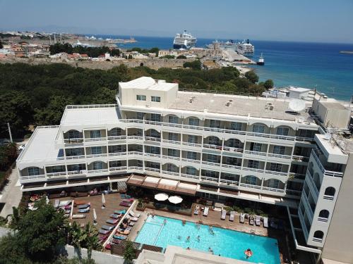 een hotel met een zwembad en de oceaan op de achtergrond bij Athineon Hotel in Rhodos-stad