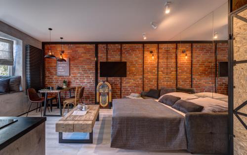 sala de estar con sofá y pared de ladrillo en Apartamenty Colobrzeg Loft, en Kołobrzeg