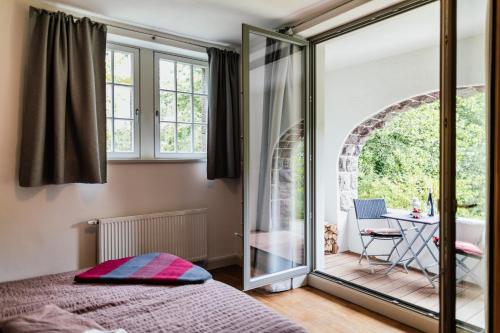 a bedroom with a bed and a balcony with a table at Ferienwohnung VILLA FRÜBING in Ilmenau