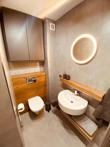 a bathroom with a white toilet and a sink at REWAL Komfortowy apartament przy plaży typu STUDIO in Rewal