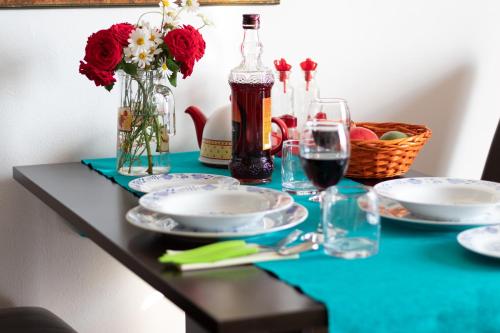 a table with plates and glasses of wine and flowers at Mirta in Stara Baška