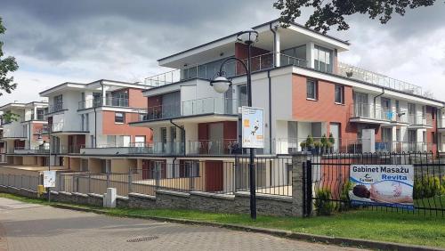 a building with a fence in front of it at REWAL Komfortowy apartament przy plaży typu STUDIO in Rewal