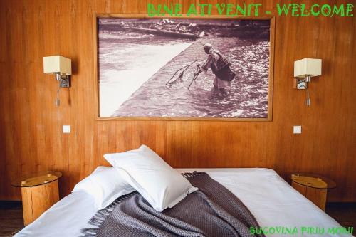 a bedroom with a picture of a man in the water at Pension Pîrîu' Morii in Gura Humorului