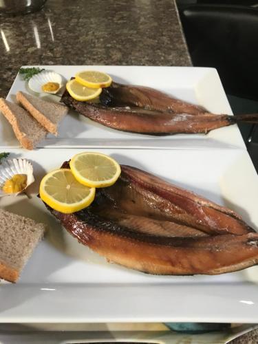 a plate of food with fish and lemon slices at The Old Barn Bed & Breakfast in Chathill