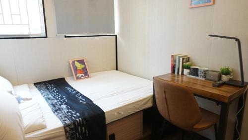 a small bedroom with a desk and a bed at Homy Inn North Point in Hong Kong
