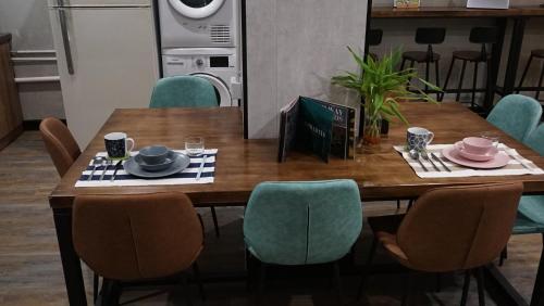 a dining room table with chairs and a table with dishes on it at Homy Inn North Point in Hong Kong