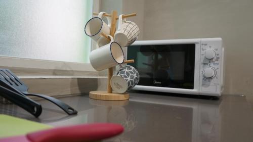 a microwave with glasses on top of a table at Homy Inn North Point in Hong Kong