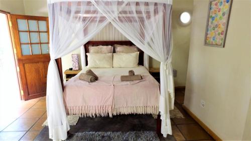 a bedroom with a bed with a canopy at Blyde Mountain Country House in Hoedspruit