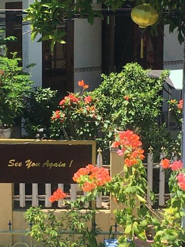 a fence with flowers and a sign that says see you again at Cherry Garden Homestay in Hoi An