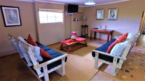 a living room with three chairs and a table at Blyde Mountain Country House in Hoedspruit