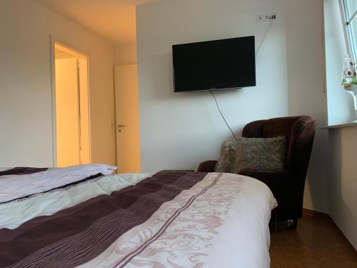 Schlafzimmer mit einem Bett und einem Flachbild-TV an der Wand in der Unterkunft Ferienoberwohnung in Villa Pesca in Cloppenburg