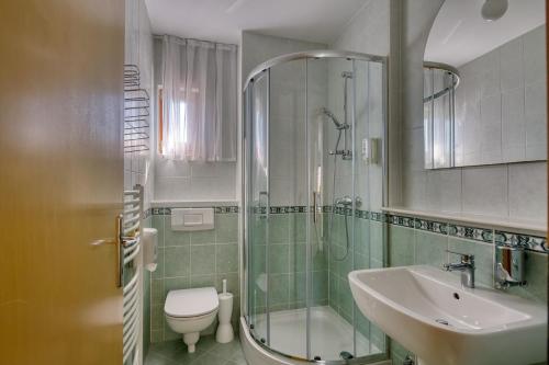 ein Bad mit einer Dusche, einem WC und einem Waschbecken in der Unterkunft Garni Hotel Zvon in Zreče