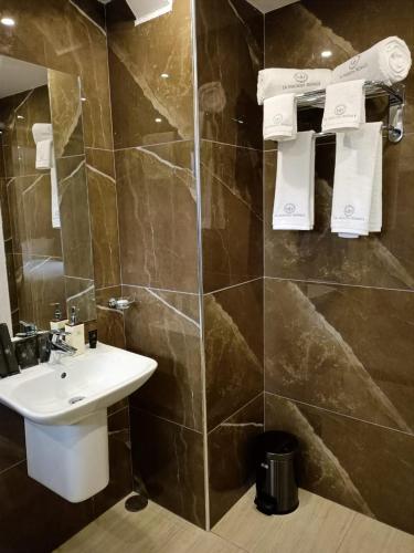 a bathroom with a sink and a tiled wall at La Maison Royale South C in Nairobi