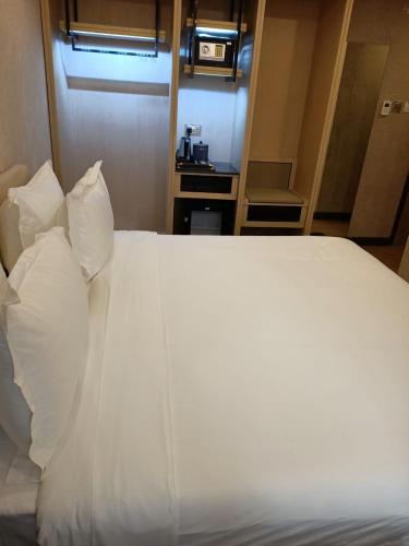 a large white bed with pillows in a room at La Maison Royale South C in Nairobi