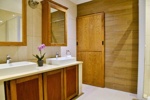 a bathroom with two sinks and a wooden door at La Perle in Ballito