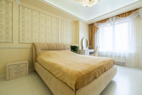 a bedroom with a large bed and a chandelier at SC Apart Ostrovskogo 93d in Perm