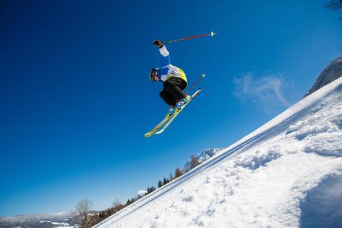 Ein Mann, der auf Skiern durch die Luft fliegt in der Unterkunft Pension Bergblick in Ruhpolding