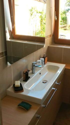 La salle de bains est pourvue d'un lavabo blanc et d'une fenêtre. dans l'établissement Gite La Granica, à Bosset