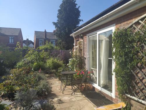 a patio with a table and chairs in a garden at Offa Hideaway in Leamington Spa