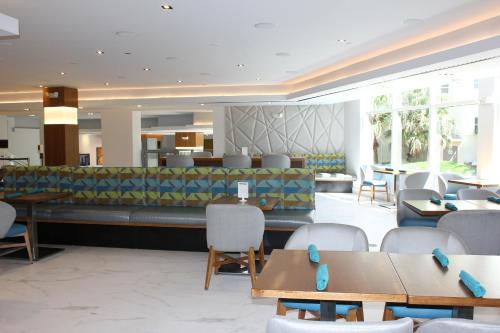 a lobby of a hotel with tables and chairs at Holiday Inn Miami Beach-Oceanfront by IHG in Miami Beach