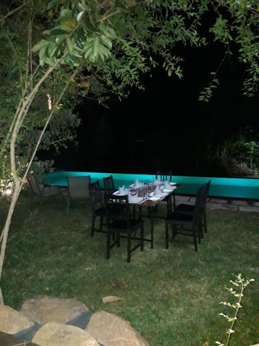 a table and chairs in a backyard with a pool at Vimanra Udawalawa in Udawalawe