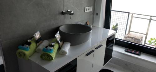 a bathroom with a sink and towels on a counter at Waterfront Glass Flat in Kusadası