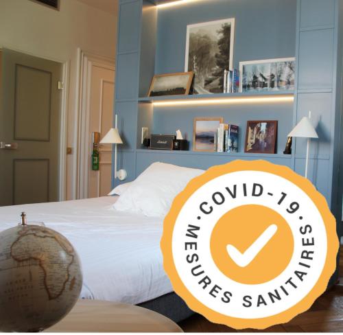 a bedroom with a bed with a sign that reads the cool hotel cakes sandwich at Hôtel et Spa La Villa K - Basel Airport in Saint-Louis