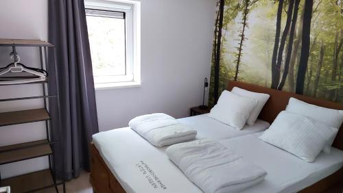 a bedroom with two beds with white pillows and a window at 't Edelhert in Nunspeet