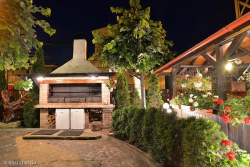 a outdoor patio with a fireplace in a garden at night at Crama Haiducilor in Cluj-Napoca