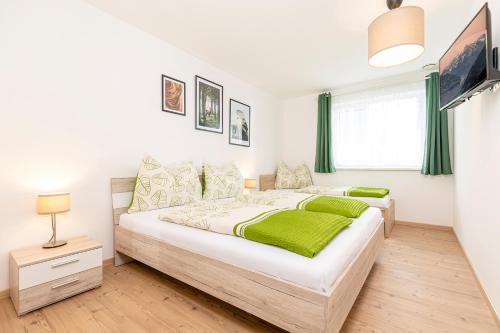 a bedroom with a large bed with green sheets at Apart Schachinger in Uderns