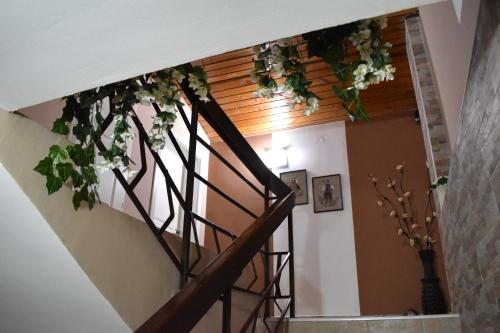 a staircase with flowers hanging from a ceiling at Guest house Kozle in Skopje