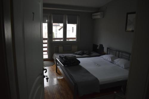 a bedroom with two beds and a window at Guest house Kozle in Skopje