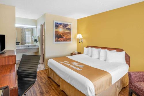 a hotel room with a large bed and a television at Days Inn by Wyndham Clarksville TN in Clarksville