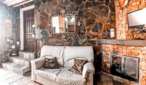 un soggiorno con divano e parete in pietra di Complejo Rural Rosa del Gamonal a Cádiar